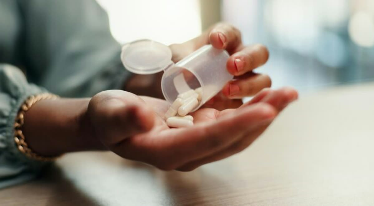 A caregiver pouring medication into a resident’s hand