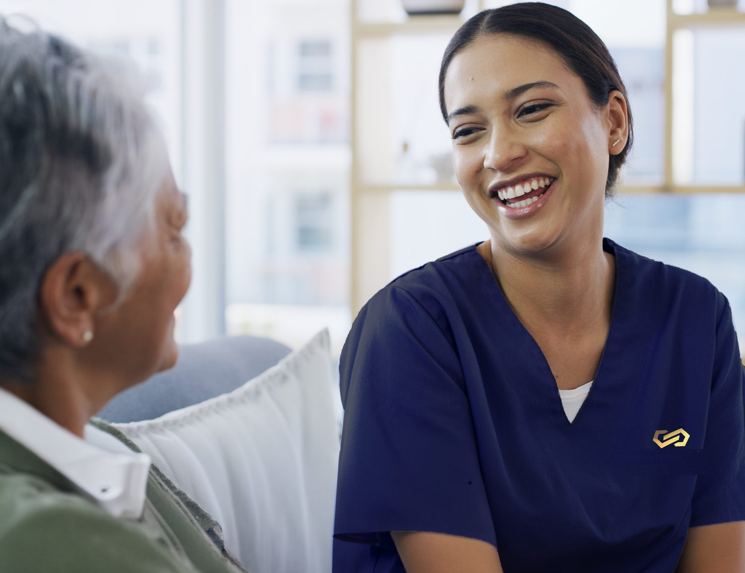 A smiling caregiver sharing a laugh with a senior resident